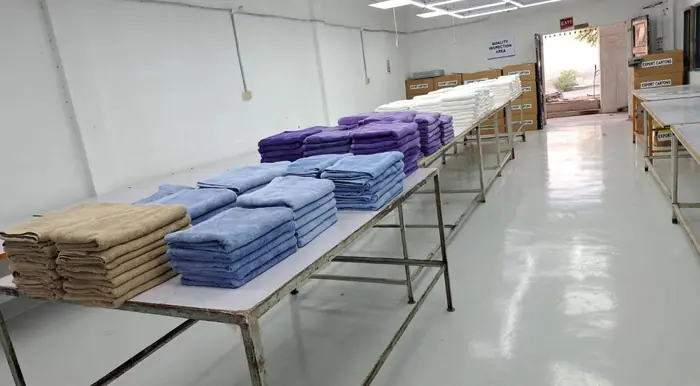 A long table of folded towels in a clean packing room
