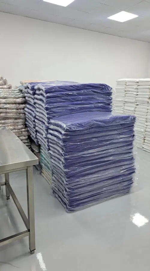 Stacks of wrapped towels beside a steel table